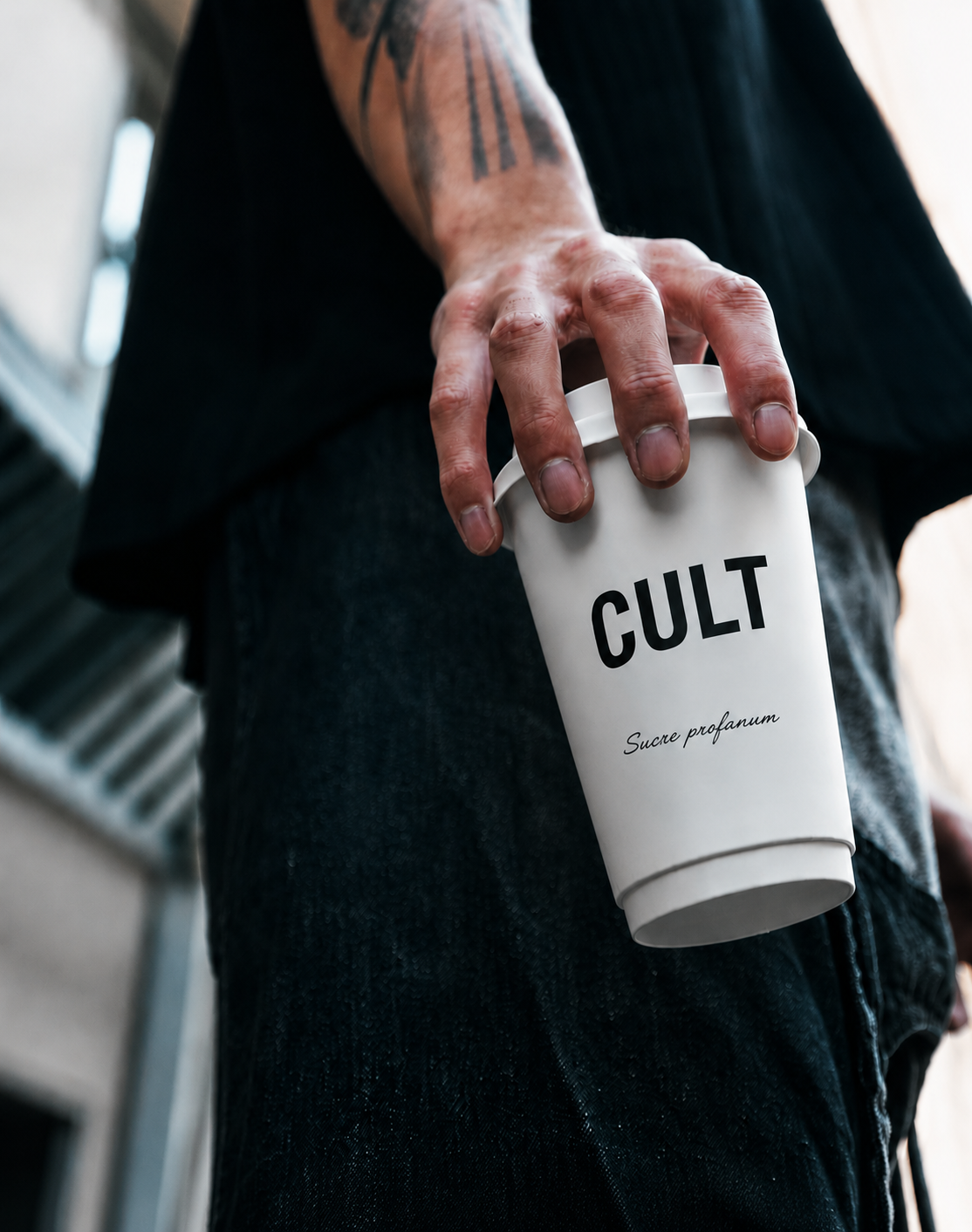 Une main tenant un gobelet CULT Paris &agrave; emporter.